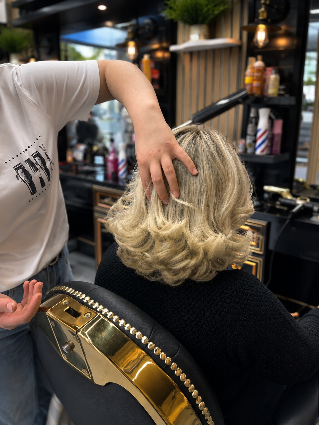 Blond kapsel met slagen in een zwart-gouden stoel, net klaar in de zaak
